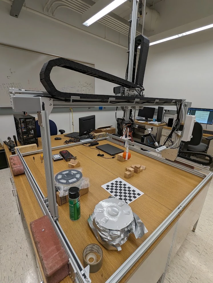 The gantry workspace with calibration targets, test objects, and build materials.