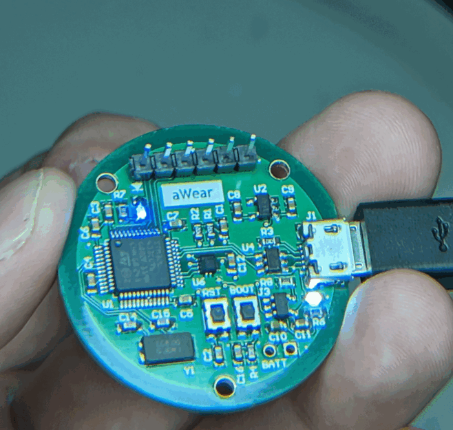 The populated cardiac monitor board held with a cable connected.