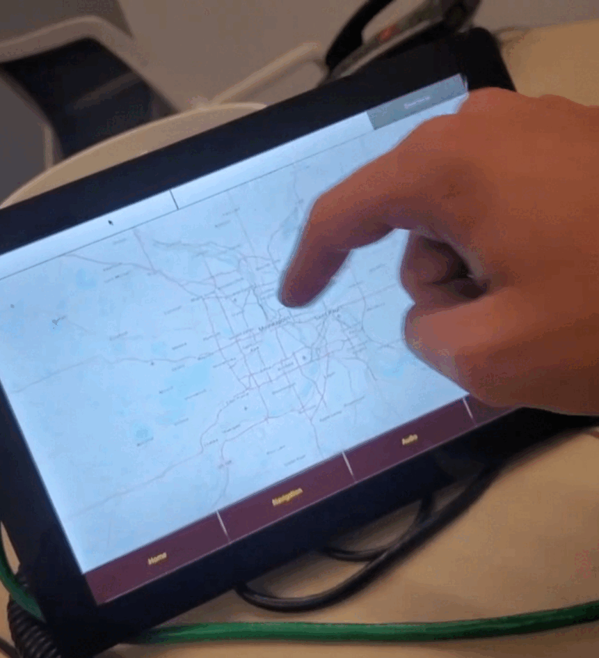A hand interacts with a map displayed on a tablet.