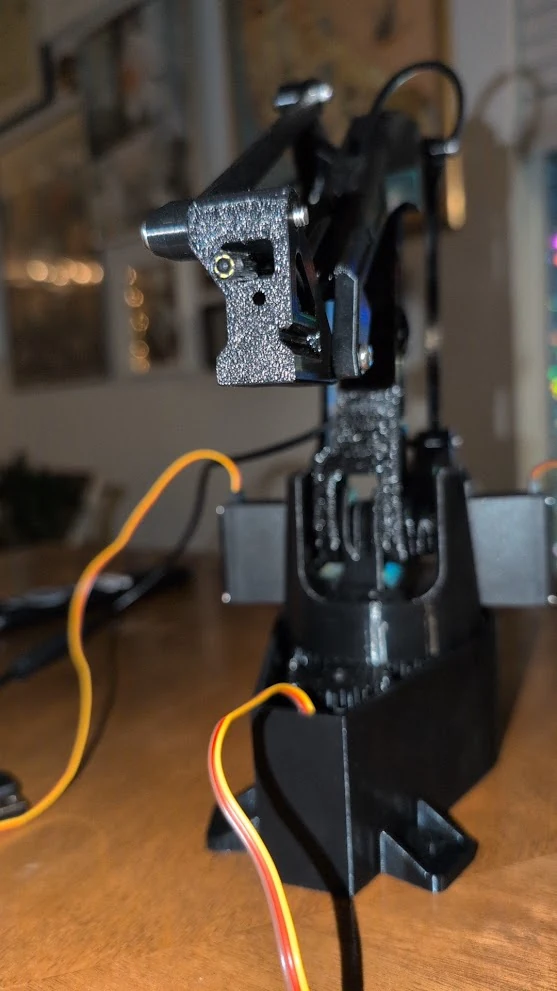 An early printed camera-arm prototype on the workbench.