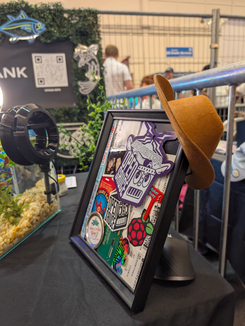 Exhibitor badges and mementos beside the aquarium.